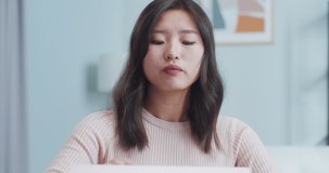Close up of beautiful Asian woman working at home office with modern minimalist design. Young female freelancer opening laptop computer, starting work. Business, occupation, job concept.