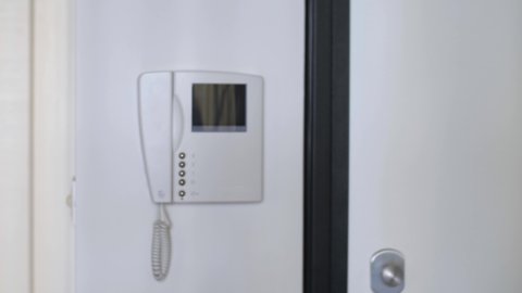 White Video Intercom that Turns on at the Ringing of the Doorbell and Response from a Man