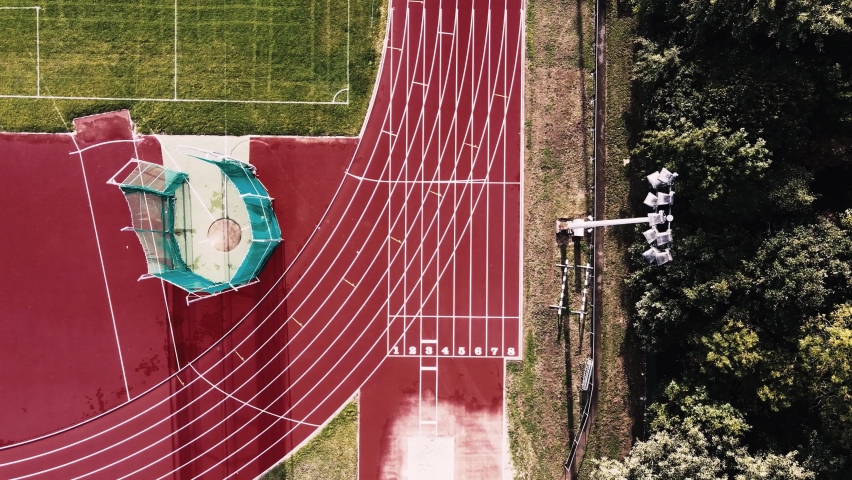 Drone aerial shot of running track at an outdoor sports stadium. Starting a race from starting blocks Royalty-Free Stock Footage #1058761414