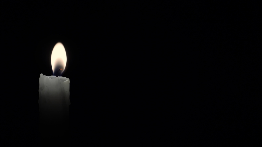 Candle. Seamlessly loop footage with copy space. Burning candle isolated on a black background. Infinitely flame of a white candle in the night. Royalty-Free Stock Footage #1058763235