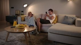 Competitive Couple Playing Mobile Games On Their Smartphones At Home 