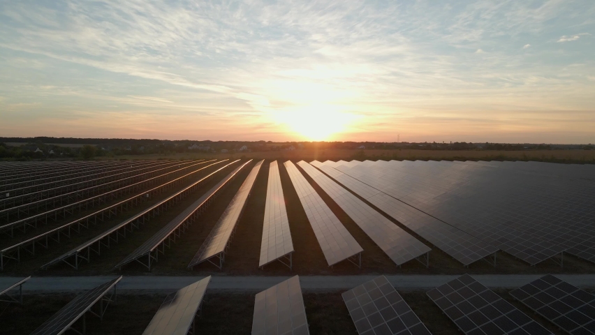 Aerial drone view of large solar panels at a solar farm at bright sunset. Solar cell power plants. footage video 4k. Royalty-Free Stock Footage #1058763652