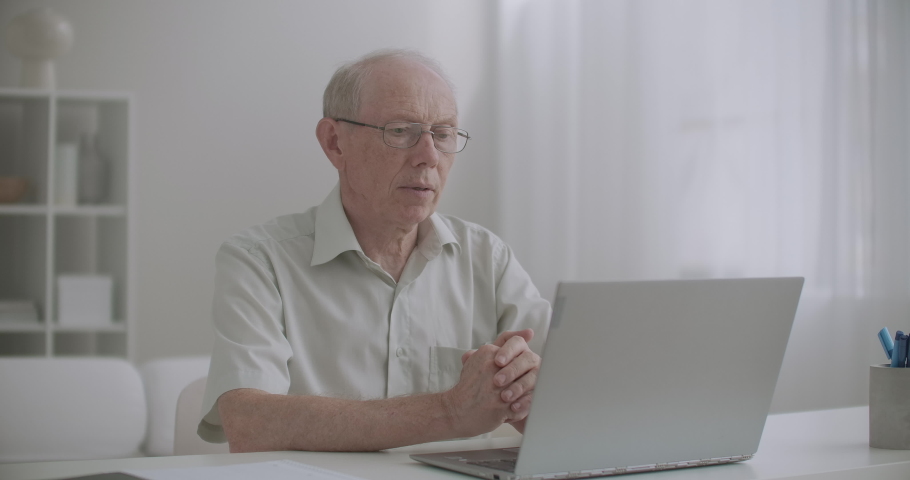 elderly man is using online consultation with specialist by laptop with internet, staying at home and calling by video Royalty-Free Stock Footage #1058763853