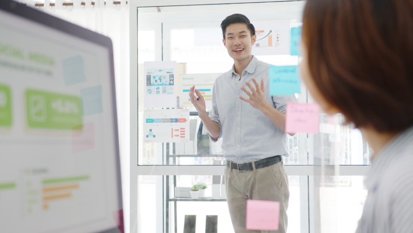 Asia businesspeople meeting brainstorming conducting business presentation ideas project colleagues and wear protective face mask back in new normal office. Lifestyle and work after corona virus. | Shutterstock HD Video #1058772292