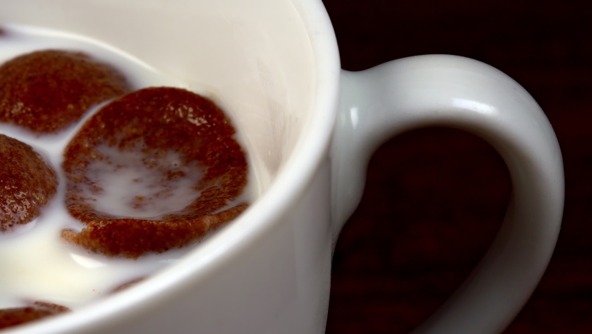 Macro view of chocolate cereals in milk.