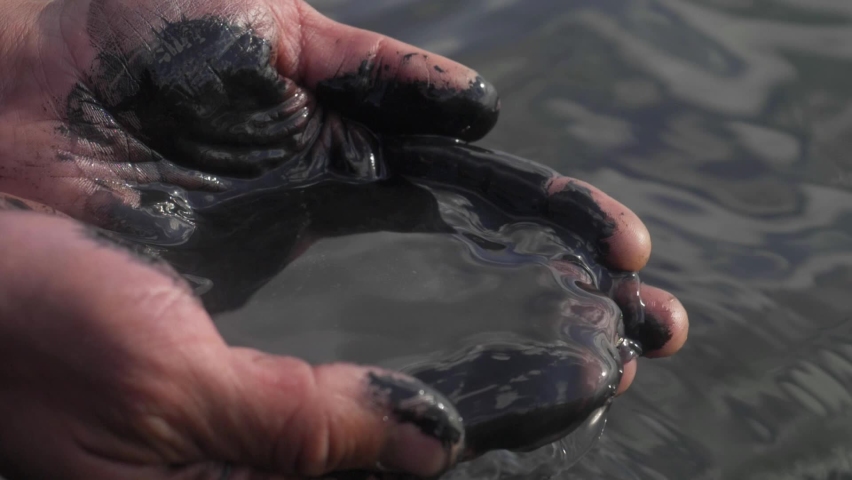 oil in human hands, oil slick, petrol pollution disaster. contamination of water, polluted water concept. lack of fresh drinking water for agriculture and farming. water pollution by petroleum oils Royalty-Free Stock Footage #1058777059