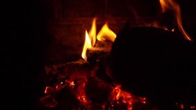 Flames in a fireplace and someone putting wood at fire in slow motion