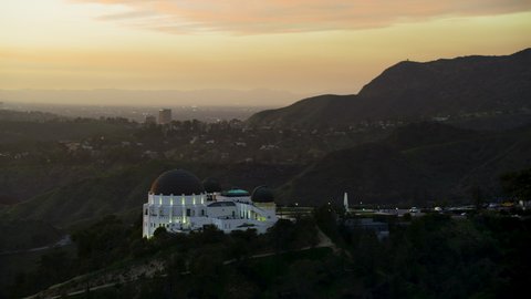 Los Angeles, California, circa 2019: Beautiful view of the Griffith Observatory and the Hollywood sign in the background. Sunset over the hills. Shot on Red Weapon 8K.