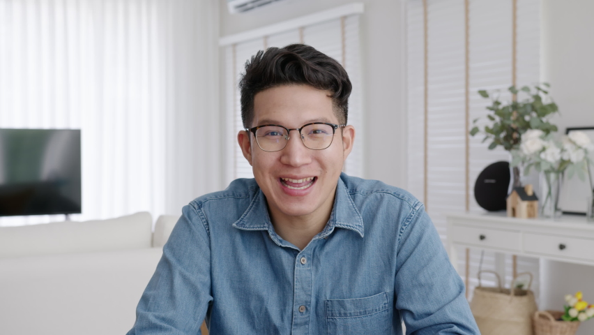 Medium shot ,confident asian creative man vlogger make live video conference call, chat online on computer and sitting on table at home, Webcam view, video chat and Self isolation concept. Royalty-Free Stock Footage #1058778940