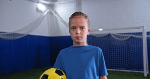 Portrait of Young little boy playing in the field with soccer ball. Football professional training, talented kids, motivational video. Children player on professional stadium.