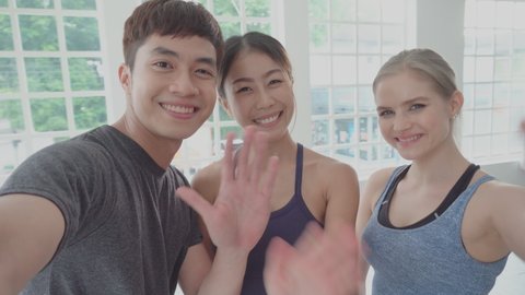 POV angle group of diversity friend waving hand selfie photo and video together in sportswear at fitness. happy people after exercise. connecting to technology and social  media lifestyle