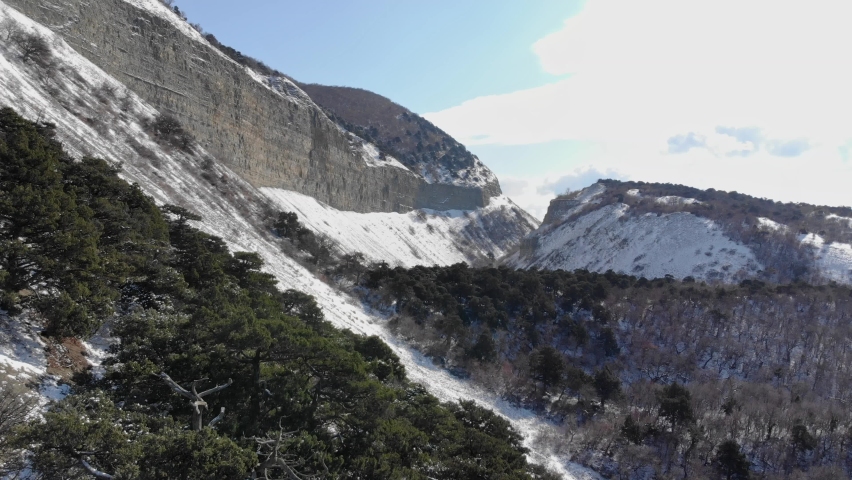 Canyon with snow in winter and sunlight, aerial view. Russia, Utrish