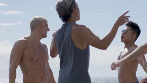 Summer fun! A diverse group of LGBTQ men dancing on a beach. Having fun summer days on vacation. Shot in 4k!