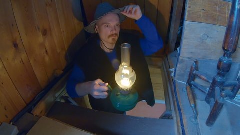  Man in a cowboy hat with an old, kerosene lamp goes up to the attic. Sees something very scary and is very scared.