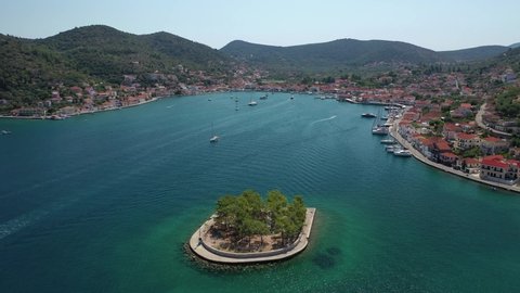 Aerial drone video of picturesque village capital and port of Ithaki or Ithaca island a safe anchoring for sail boats featuring small islet of Lazareto with small chapel built on it, Ionian, Greece