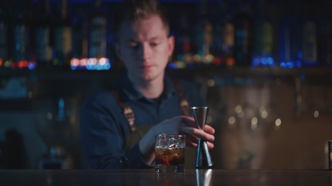 bartender preparing white russian cocktail in night club