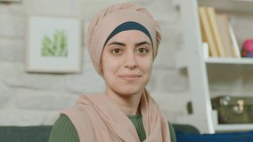 Young muslim woman smiling while looking at camera. Beautiful smiling woman portrait.Close up.Slow motion video.