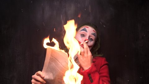New York, USA - 12 October 2019: Joker Cosplay Actor Smoking and burn the New York Times Newspaper