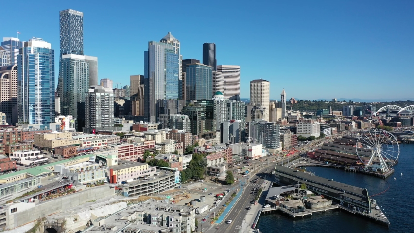 Aerial / drone footage of the Seattle waterfront, Great Wheel, Belltown, Elliott Bay with few people downtown, in the commercial district of Seattle, Washington during the pandemic