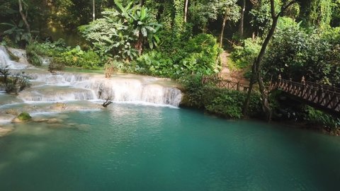 Magical Natural Pool Under Exotic Waterfall in Rainforest, Panoramic Aerial. Kuang Si Falls, Laos Asia