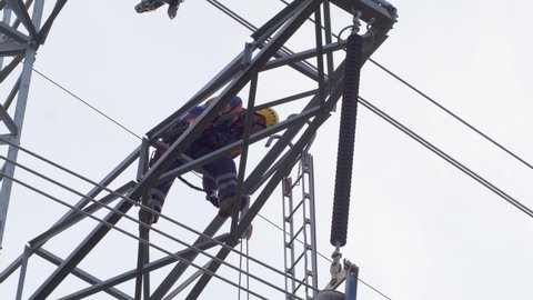 Electrician climbs on electric poles to install and repair power lines