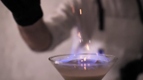 Bartender Strew Cinnamon Powder to Flame of Cocktail, Flaming Cocktail Alcohol Drink, Bar Party