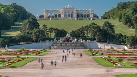 VIENNA, AUSTRIA - CIRCA AUGUST 2019: Gloriette pavilion and Neptune fountain in Schonbrunn park timelapse. People walking in the park. Vienna, Austria
