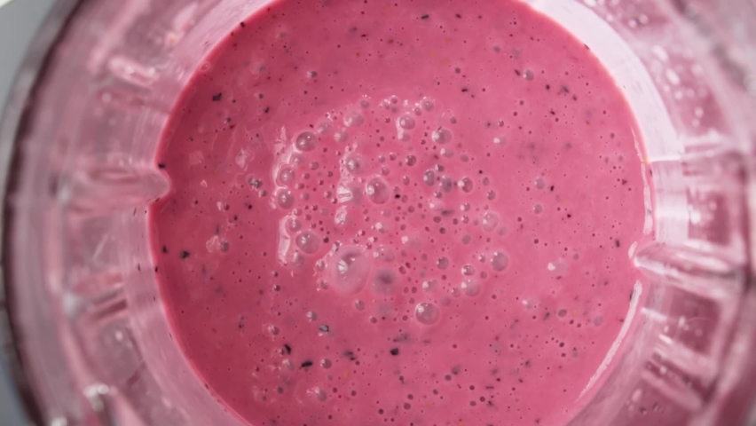 Red berry smoothie blended in blender with splashes, top view, slow motion. Healthy eating concept. Royalty-Free Stock Footage #1058812660