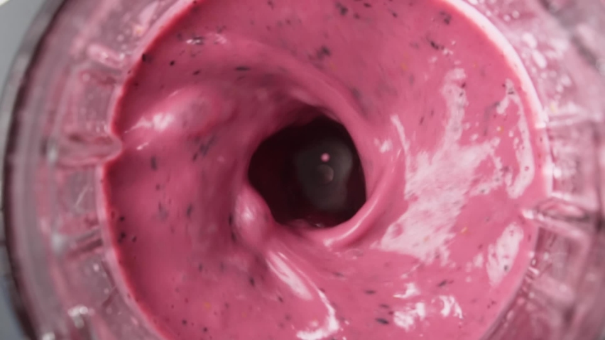 Red berry smoothie blended in blender with splashes, top view, slow motion. Healthy eating concept. | Shutterstock HD Video #1058812660