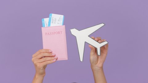 Close up cropped traveler tourist woman hands give hold passport ticket plane isolated on violet background. Passenger traveling abroad to travel on summer weekends getaway. Air flight journey concept