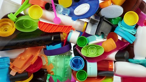 Plastic waste background. Various colorful plastic products, time lapse.