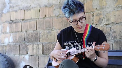 Beautiful girl playing ukulele and singing