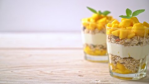 fresh mango yogurt with granola in glass - healthy food style