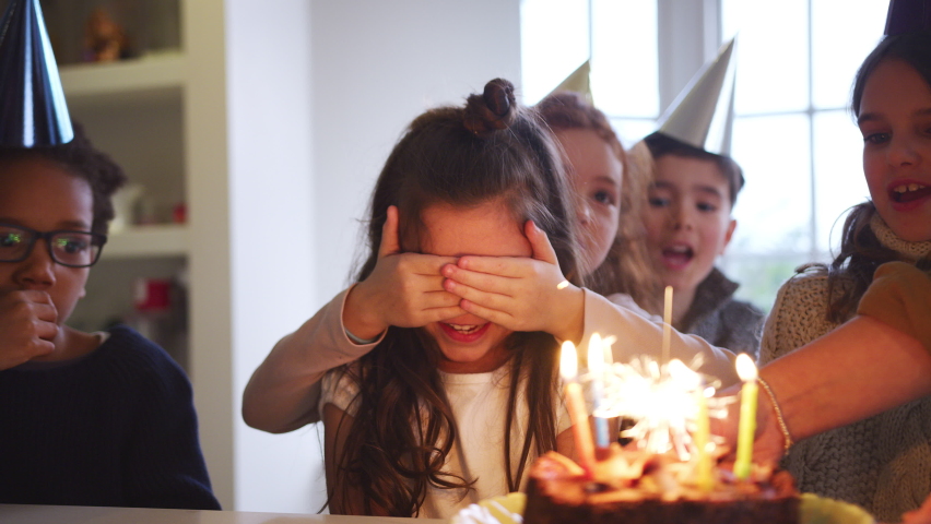 Girl Celebrating Birthday With Friends At Home Being Given Cake Decorated With Sparkler And Candles | Shutterstock HD Video #1058819041