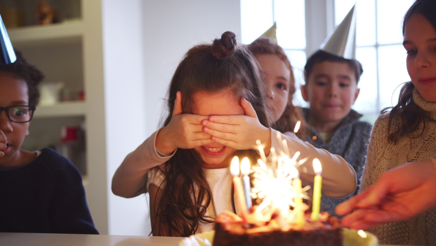 Girl Celebrating Birthday With Friends At Home Being Given Cake Decorated With Sparkler And Candles