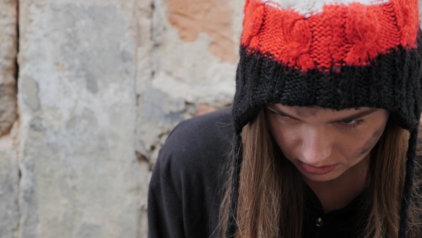 Portrait of a beautiful homeless woman. Sad and tired look of a beggar