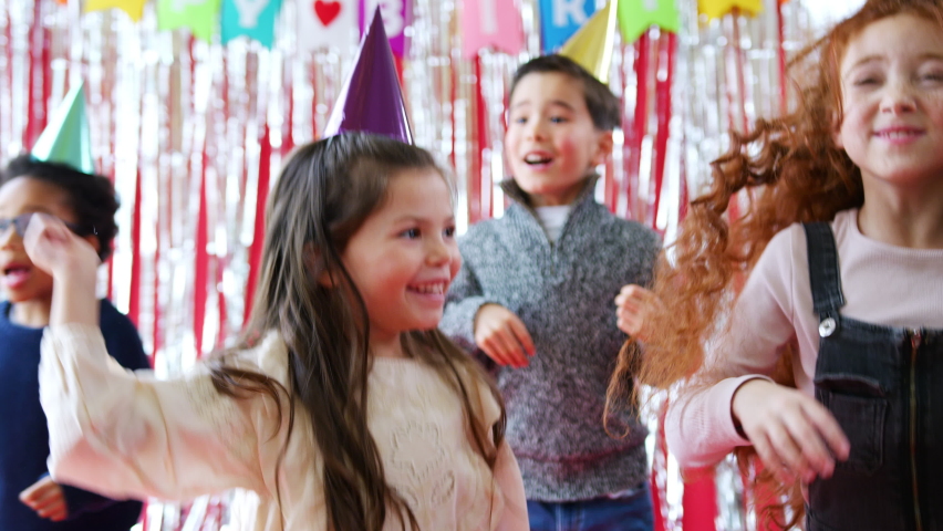 Group Of Children In Party Hats Celebrating At Birthday Party With Streamers And Gold Confetti | Shutterstock HD Video #1058822344