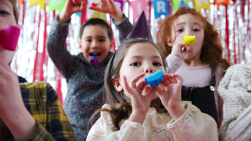 Group Of Children Celebrating At Birthday Party With Paper Hats And Party Blowers | Shutterstock HD Video #1058822353