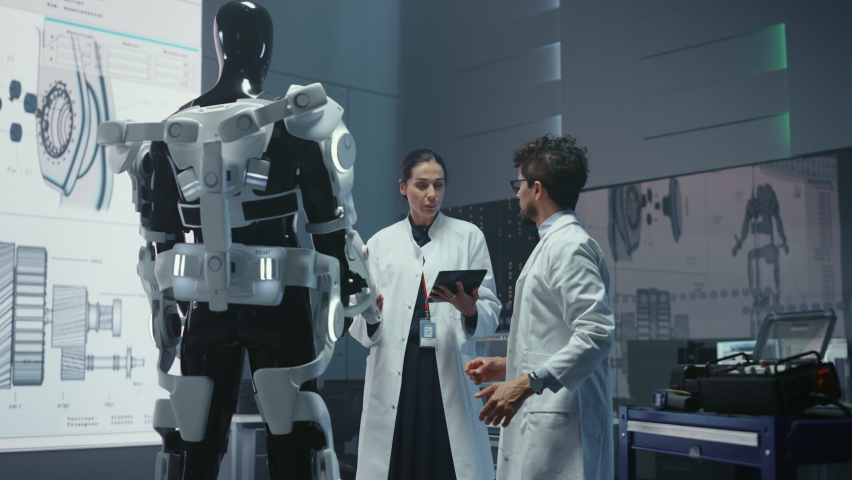 In Robotics Development Laboratory: Chief Female Engineer and Top Male Scientist Work on a Bionics Exoskeleton Prototype. Designing Powered Exosuit to Help Disabled People, Hard Labor Workers	 Royalty-Free Stock Footage #1058828512