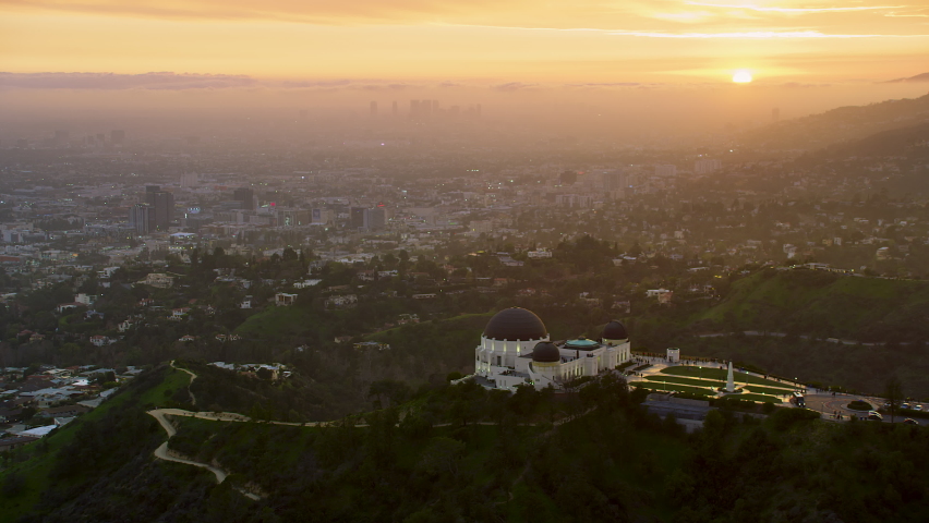 Amazing view of the Griffith Observatory in Mount Hollywood. Crowded entrance lawn and observation deck. Los Angeles, California. Beautiful sky during sunset. Shot on Red Weapon 8K.