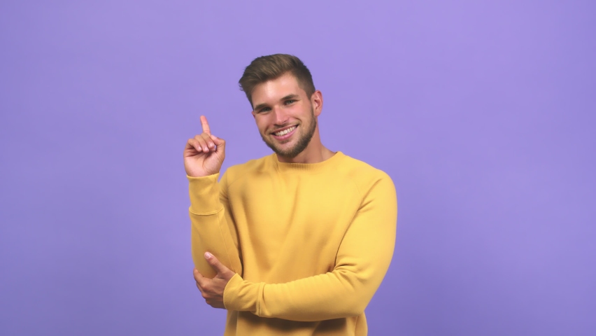 Young caucasian handsome man pointing to the side, smiling surprised presenting something, natural and casual