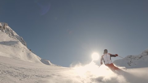 skier skiing on ideal ski slope in big mountains on sunny day behind camera. Winter outdoor activities. Slow motion, 2K RAW footage, 2704x1520