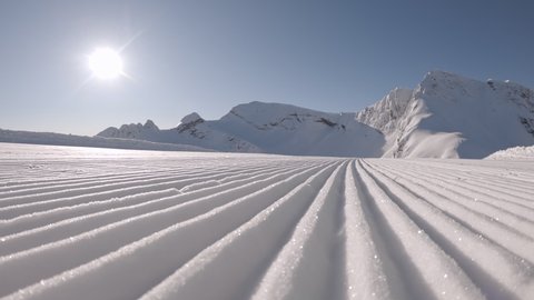 CU DOLLY SHOT of fresh groomed perfect corduroy slope on a skiing resort. Fresh Corduroy Pattern on Snow. Perfectly groomed snow. 2K UHD RAW graded footage
