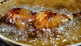 Frying Chicken leg piece in deep oil. Leg piece fry close up video.