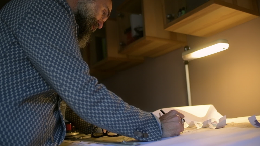 Man leaning over table and drawing, Cameri, Novara, Italy