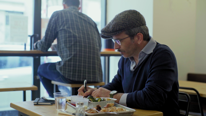 Man sitting in restaurant and writing, Turin, Italy