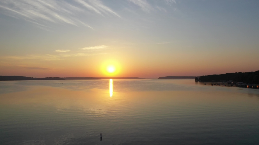 Lake Geneva, Wisconsin during golden hour with glassy sun reflection off of the water from a aerial view.