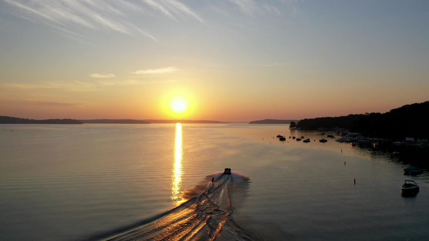 Water skiing on lake Geneva, Wisconsin during golden hour from a aerial view.