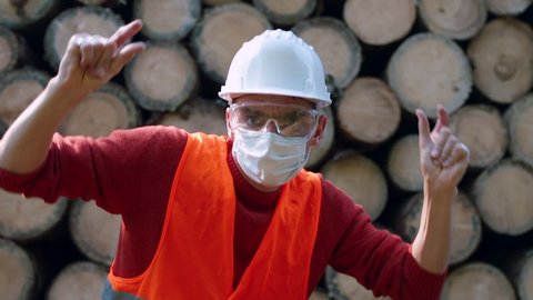 Portrait male engineer doing dance moves wearing face mask. Demonstration joy new job. Motivating positive attitude at sawmill. Successful completion project. To please manager in quarantine COVID-19.