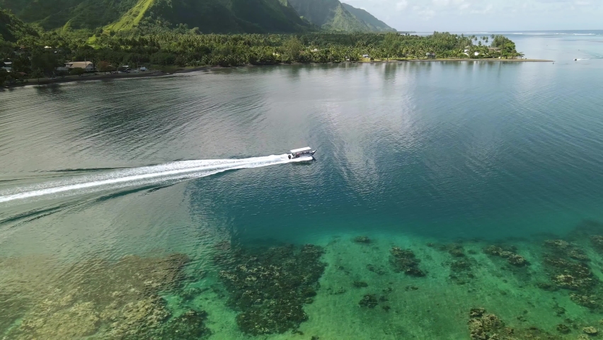 Drone aerial shot 4k. Boat in ocean lagoon. Tropical paradise, Tahiti adventure vacation, summer surf, island travel in French Polynesia.  Royalty-Free Stock Footage #1058855779